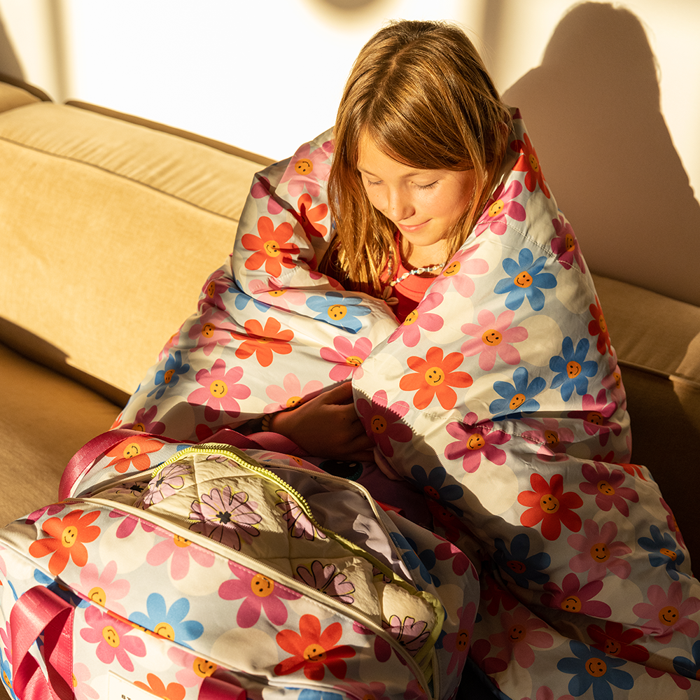 Girl wrapped in STATE Bags Redwood Sleeping Bag Daisies