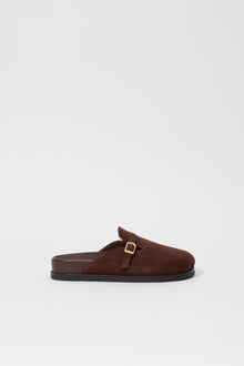 Brown suede slipper with gold buckle detail and black sole, shown in side view.