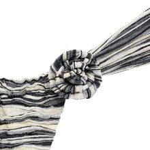 Gathered rose-shaped knit pin in black and cream striped slub knit fabric with trailing fabric strips.
