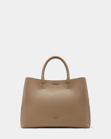 The Rudsak CATIRA L - 8325007 Almond is a taupe leather womens tote with a pebbled finish, two rounded handles, and a subtle metallic logo near the base, shown on a plain white background.