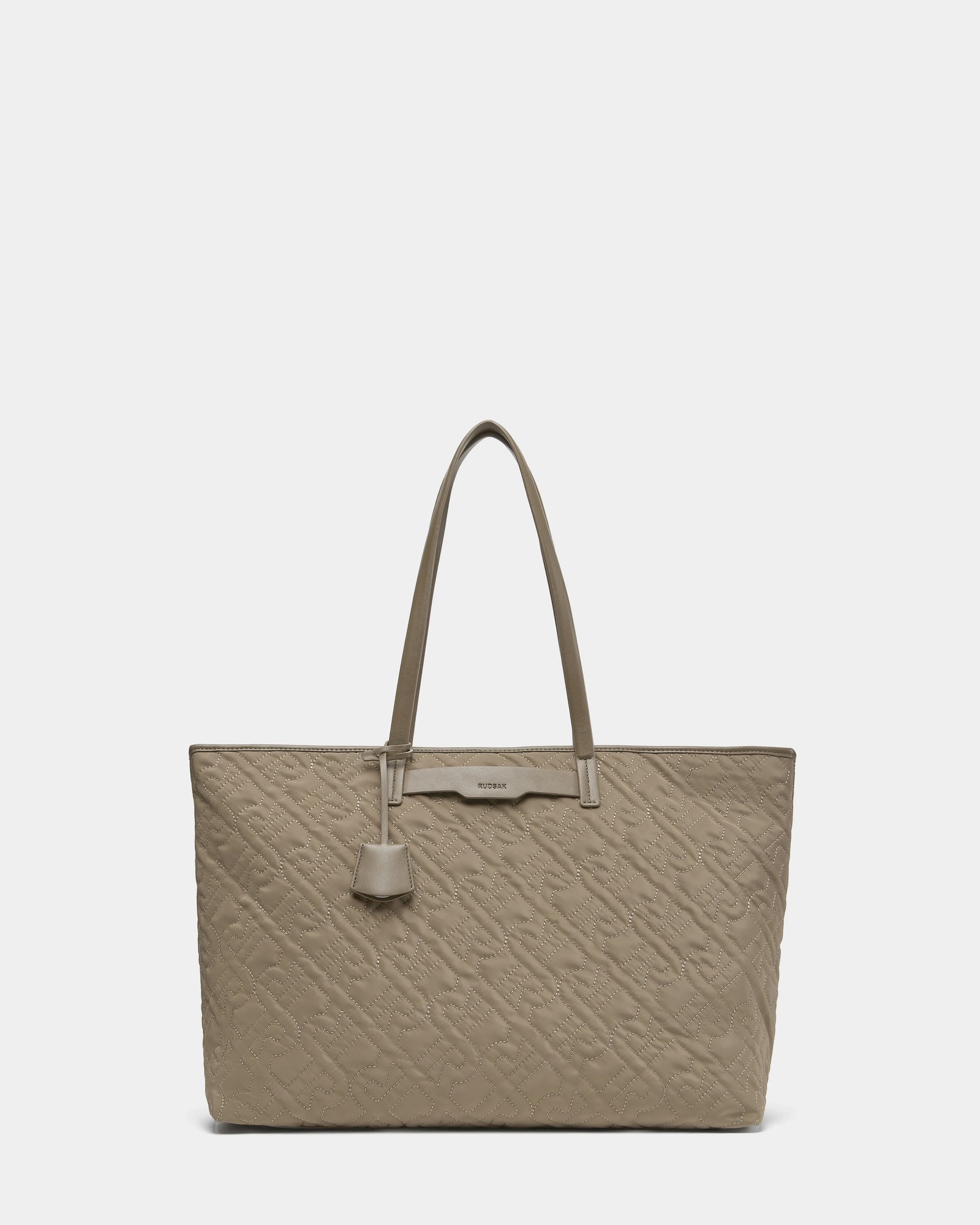 A stylish Rudsak LIVORNO - L325007 Almond tote bag in taupe quilted design, featuring two long handles and a decorative leather tag, displayed against a plain white background—everyday luxury redefined.