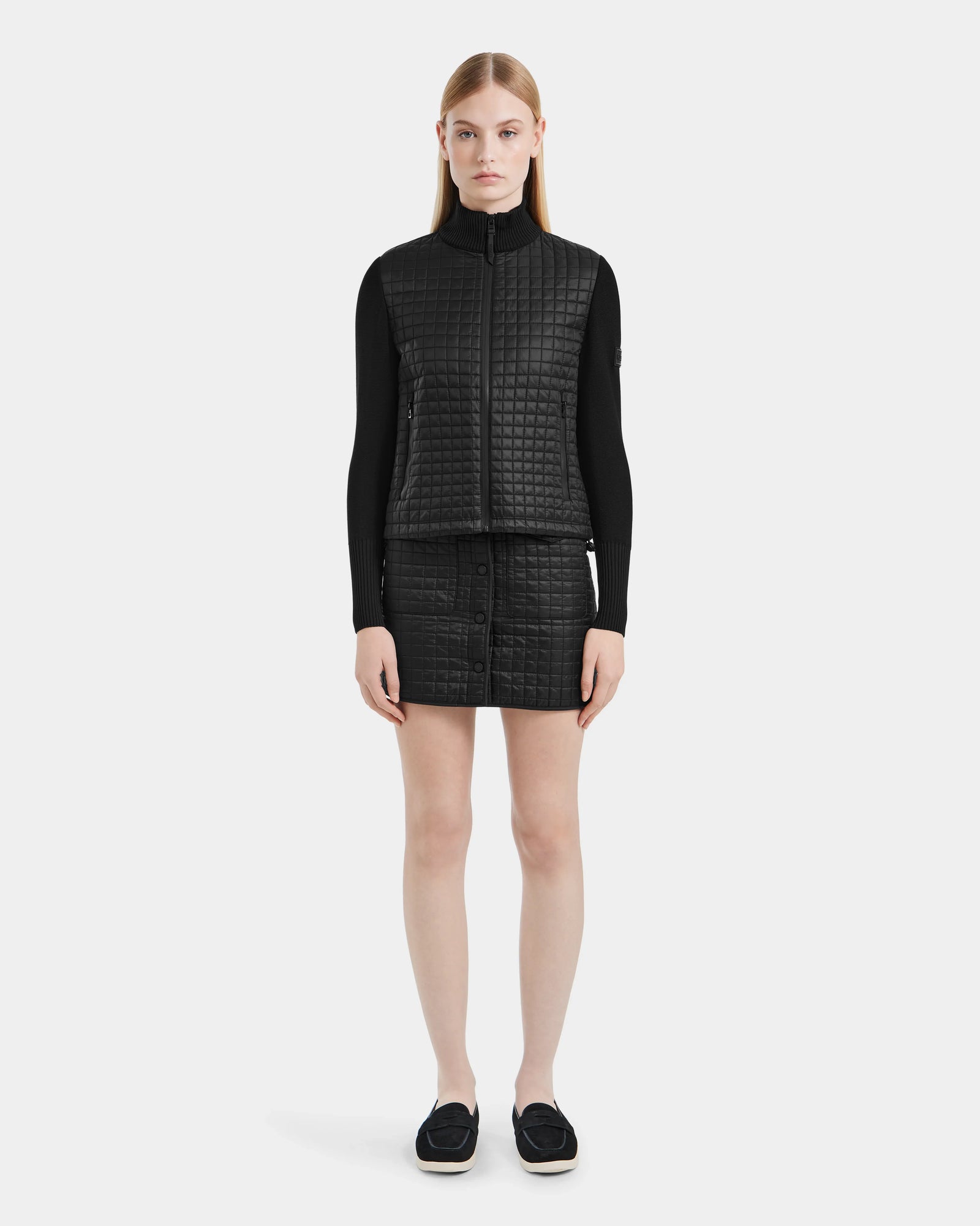 A woman in a black Rudsak LOUISE - 8124046 lightweight quilted jacket with RDS-certified down.