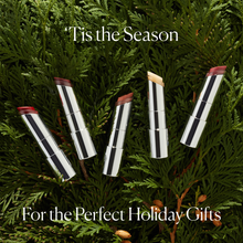 lipstick tubes on a green fir background