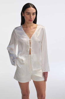 Woman wearing a white outfit with a plain background