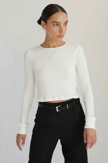 Woman wearing a white long sleeve top with black pants
