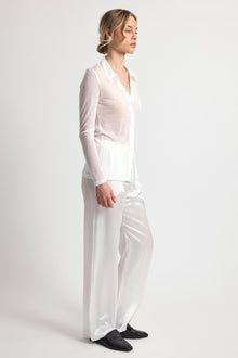 Woman wearing a white outfit on a plain background