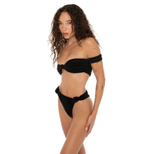 Side view of the Aimi Bikini Bottom in black with knotted hip detail, paired with matching bandeau top. **black