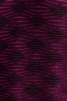 Close-up of the fuchsia aubergine Ines pencil skirt, highlighting the textured pattern in vibrant fuchsia and deep aubergine colors. Ethically made from baby alpaca and cotton.