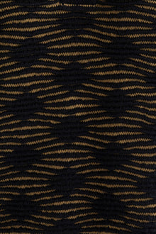 Close-up of the golden black Ines pencil skirt, highlighting the textured pattern in golden and black. Ethically made from baby alpaca and cotton.