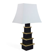 Table lamp with a black and gold base and white shade on a white background