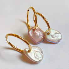 Coin pearl hoops styled together on a white background